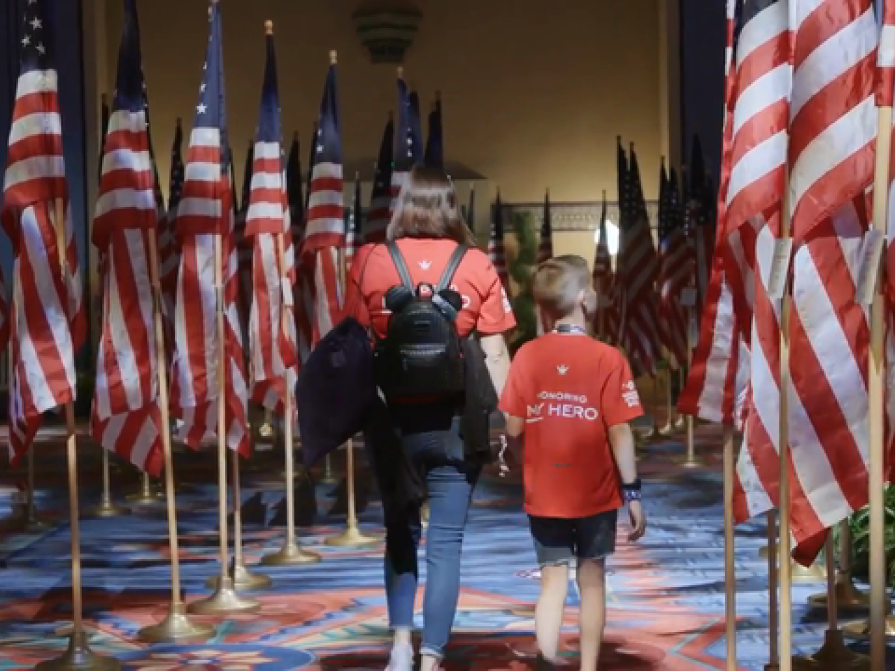 children walking through rows of American flags