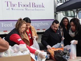 KeyBank volunteers working with The Food Bank volunteers preparing food bags.