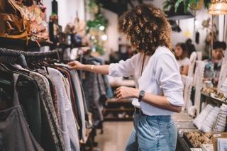 女人看着衣服架在一家商店