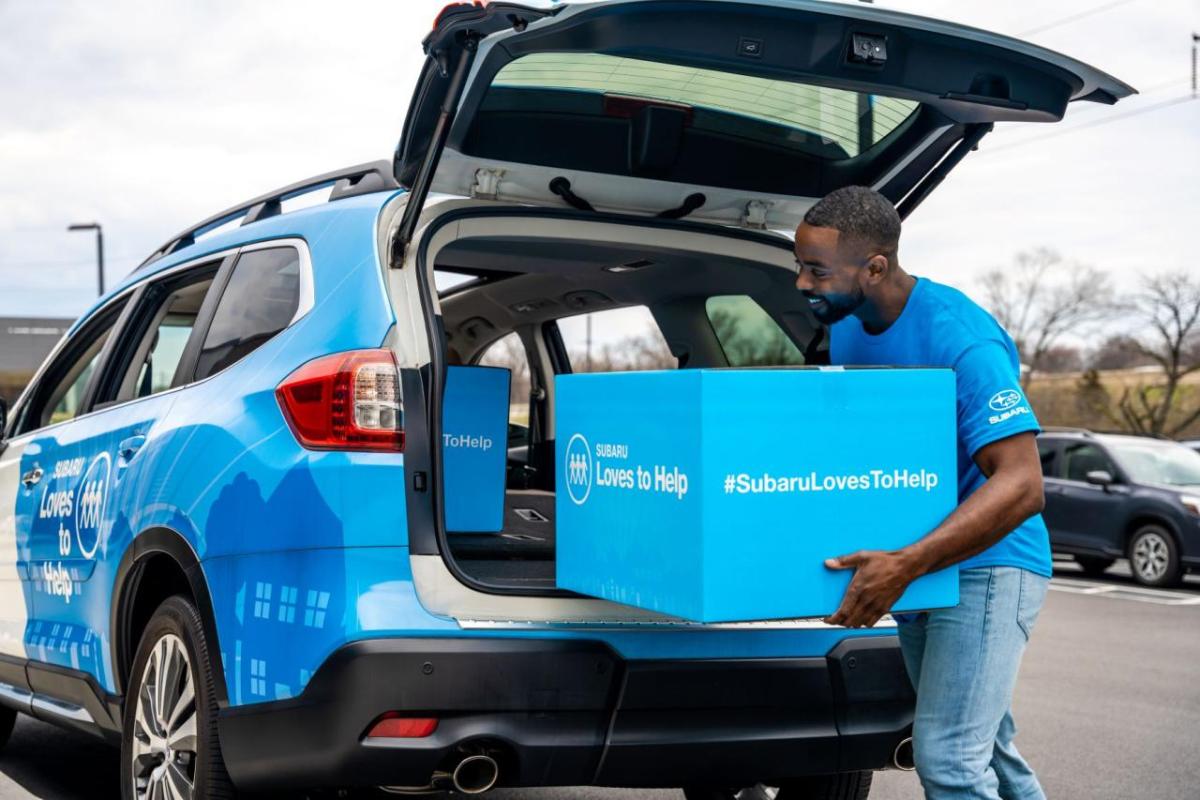 Loading a box into the back of a Subaru