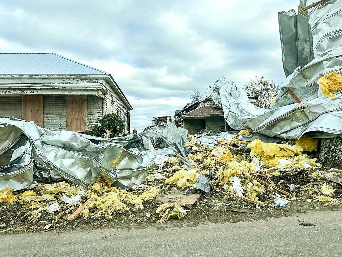 街景tornado-damaged建筑,绝缘部分随处丢弃,防水布覆盖。